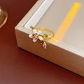 Macro shot of gold-plated flower ring with white enamel petals and sparkling crystals - Ring-Gold-White
