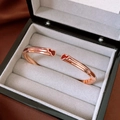Détail du bracelet ouvert en or rose avec gourdes en émail rouge dans un coffret cadeau - Jonc Ouvert Coeur Rouge Or Rose