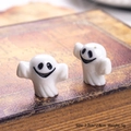 Detailed macro shot of 3D mini ghost figurines on a vintage book for Halloween decor - Long Mouth White Ghost