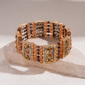 Detail van de vintage gouden stretcharmband met amber kralen en metalen gravures - Vintage Etnische Meerlaagse Brede Kralen Armband