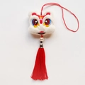 Dettaglio di un ciondolo leone in peluche con nappe rosse, perle e cappuccio in metallo - Leone Felice (Bianco)