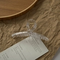 Elegant large transparent milk tea hair claw clip with golden spring on wooden tray - Transparent Cross
