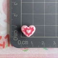 Macro shot of a pink resin heart charm measuring 1.2cm on a metric ruler for DIY projects - Pink and Watermelon Red