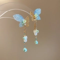 Detail of butterfly tassel earrings with blue lace wings, pearls, and golden chains - Blue
