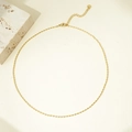 Dettaglio della collana a sfere ovali dorate con chiusura regolabile e targhetta tonda - Collana Dorata#1.5mm Piccola