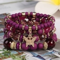 Böhmisches mehrlagiges lila Perlenarmband mit goldenem Schmetterlingsanhänger - Rötliches Lila