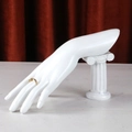 Detailed view of a gold ring with a green gemstone on a white mannequin hand - Roman Column Hand / White