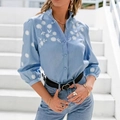 Dettaglio camicia di jeans azzurra con ricamo a margherita bianca e maniche a lanterna - S / Blu