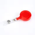 Solid red retractable badge reel with circular plastic shell and PVC strap for ID cards - Red