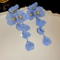 Dettaglio macro di orecchini a fiore blu con centri dorati e cristalli trasparenti lucidi - Blu