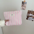 Close-up of a pink striped fabric toiletry bag with woven texture and zakka label - Pink
