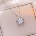 Detailed macro view of rotating silver flower pendant necklace with clear zircon petals - X1062 Steel Flower Rotating
