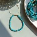 Dettaglio di un bracciale boho con perle cilindriche turchesi e accenti dorati - Perle Cilindriche Blu-Verde
