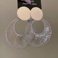 Detailed close-up of large silver circular earrings with intricate wire-wrapped texture - Silver