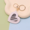 Cute light pink PU leather heart mirror keychain with gold hardware on peach background - White Heart
