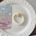 Gros plan d'un chouchou crème avec breloque ours sur une assiette en céramique blanche - Glace