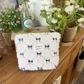 Creamy lamb wool makeup bag featuring black bow embroidery and brand logo patch - Makeup Bag