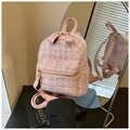 Detailed macro view of pink tweed backpack texture with premium gold metal hardware - Pink