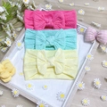 Close-up of three nylon baby headbands with bows in rose, mint green and pale yellow - 3-Pack / Rose Pink Mint Green Beige