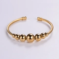 Brazalete ajustable de acero inoxidable dorado con diseño trenzado y cuentas pulidas - Dorado