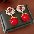 Detailed macro view of vintage gold flower earrings with red stones and pearls - Silver Earring Post-Gold-Red