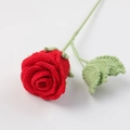 Close-up of a handmade red crochet rose bouquet with soft yarn texture and green leaf detail - Red