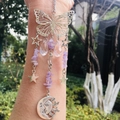 Detail of silver suncatcher featuring butterfly and celestial pendants with purple crystals - Lavender