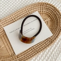 Detalle de coletero de acetato de carey con cordón elástico marrón oscuro y placa dorada - Azul Marrón Beige