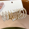 Macro-opname van Franse vintage gouden oorringen met kralenparels op een sieradenkaart - Zilveren Pin - Goud - Wit (Set)