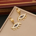 Golden evil eye hoop earrings with blue center stone on a beige jewelry box - Gold Earrings