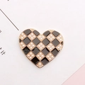 Detail of heart charm with black and gold checkerboard pattern and pearl accents - Gold