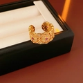 Detail of 18k gold vintage hollow ring with red and white zircon stones on a jewelry tray - Gold Style 1