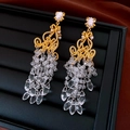Macro shot of gold-plated hollow diamond pattern earrings with crystal bead tassels - Gold-Transparent
