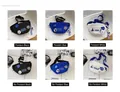 Dettaglio di borse a tracolla in nylon nero, blu e bianco con ciondoli da astronauta - Senza Ciondolo O Distintivi / Bianco Sporco