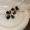 Nahaufnahme der schwarzen matten Blumenohrringe mit goldenen Linien und Zirkonia - 43# Silbernadel Schwarz Gold Hohl Blume Stecker