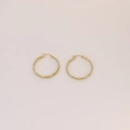 Dettaglio degli orecchini a cerchio dorati con trama a corda ritorta e finitura lucida - 3cm / Oro