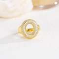 Dettaglio dell'anello bombato in oro 18k con pavé di zirconi su una base bianca morbida - Lettera O