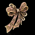 Spilla a fiocco dorata vintage con strass rosa e incisione traforata su sfondo nero - Rosa