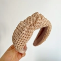 Vue détaillée du serre-tête en raphia tressé beige naturel avec un design noué - Poche zippée