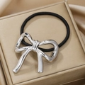 Macro shot of polished silver metal bow hair tie on luxury champagne gold gift box - Silver Small Bowknot