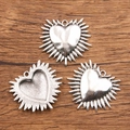 Silver metal heart charms with radial spikes and smooth surface on a wood background - 27B2-4 Radiant Light Heart