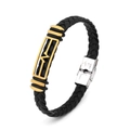 Detail of black braided leather bracelet featuring a gold maple leaf charm and silver clasp - Abstract Pattern