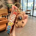 Cute brown Capybara keychain with blue bubble nose and colorful lettered hand strap - Capybara with Snot Bubble