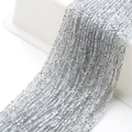 Close-up of silver faceted glass beads on cotton thread for DIY jewelry making - White String Half Silver White