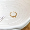 Primer plano de un anillo dorado con lazo sobre un plato de cerámica blanca - Estilo Abierto con Lazo / 1# Anillo-Dorado