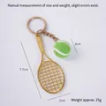 Mini tennis racket keychain featuring a golden alloy frame and a green flocked mini ball - 2cm Small Dark Green Tennis Ball + Gold Racket