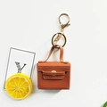 Detail eines braunen PU-Leder Mini-Handtaschen-Schlüsselanhängers mit Gold-Hardware - Braun