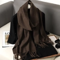 Brown faux cashmere scarf with tassels draped on a sofa with magazines and sunglasses - Brown