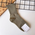 Detailed macro view of army green ribbed cotton sock with a white brand label - One Size / Army Green