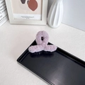 Pink faux rabbit fur hair claw clip in a twisted design on a minimalist display - Dark Purple